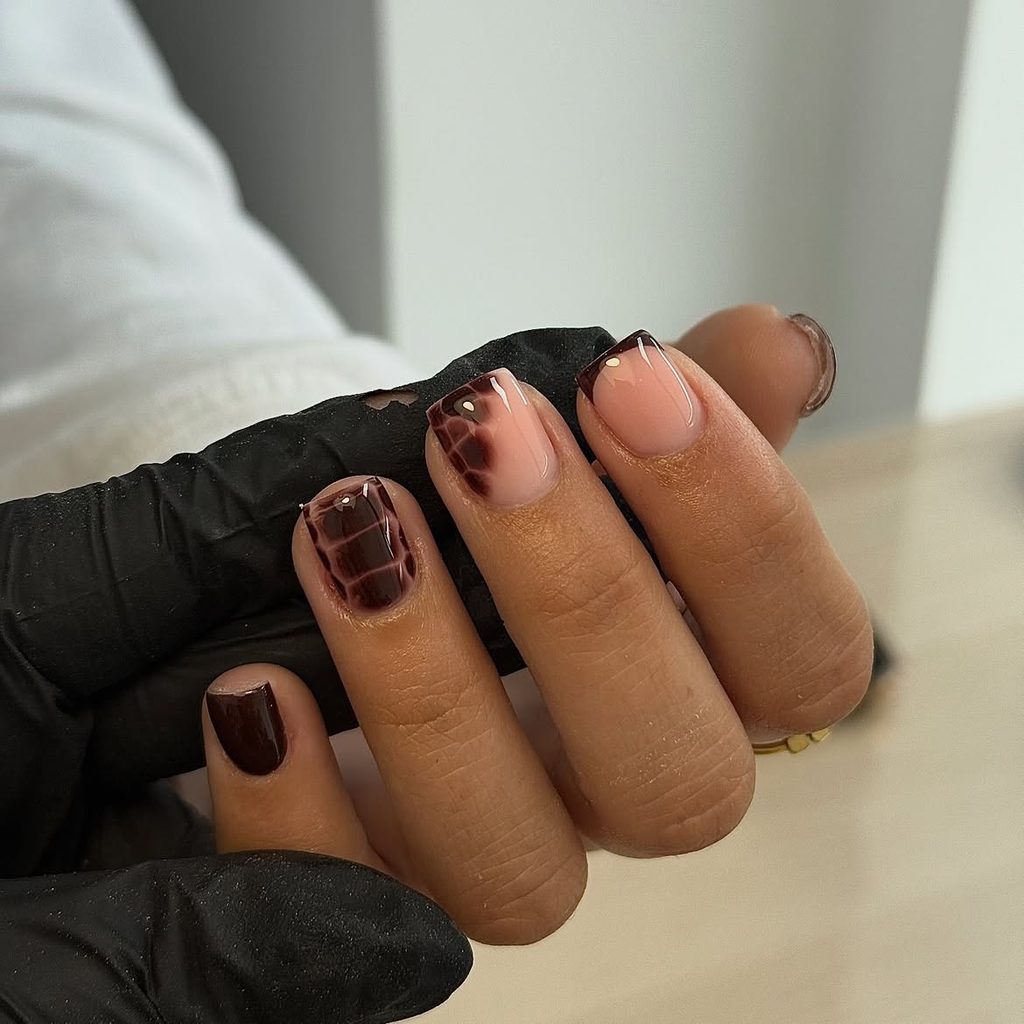 Short nails with chocolate croc-print accents, French tip, and glossy deep brown on peachy nude