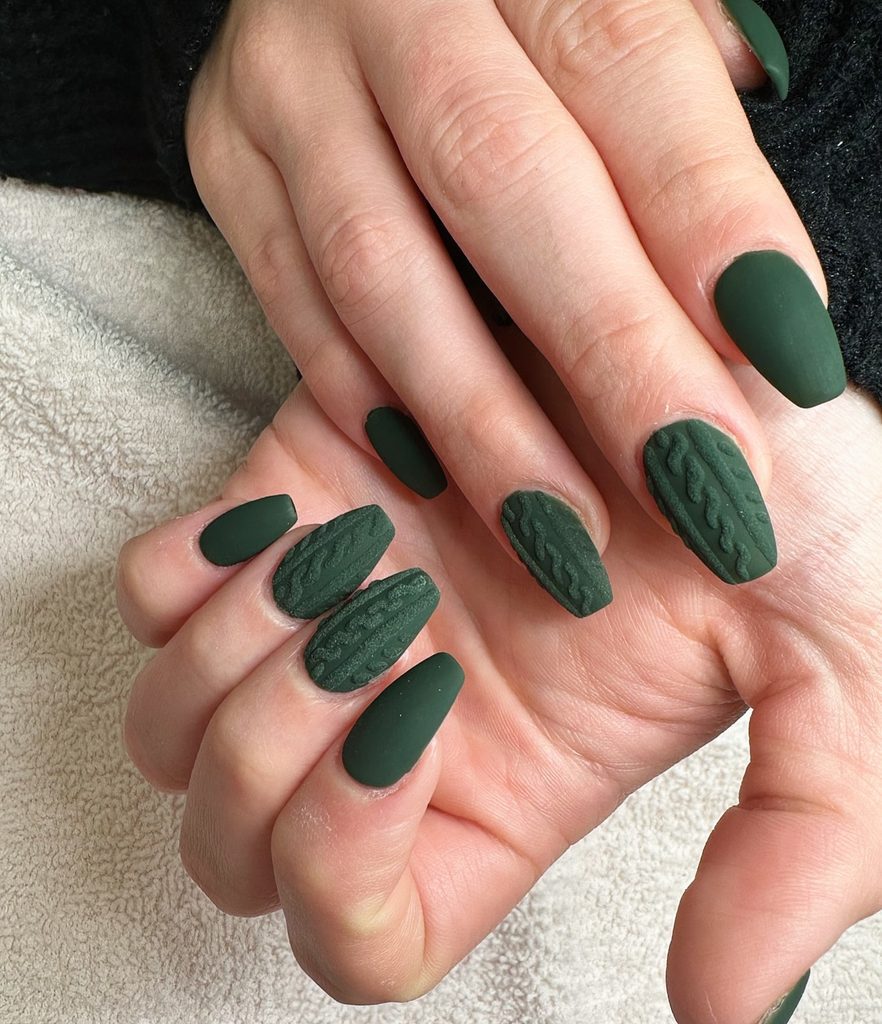 Dark green matte nails with cozy sweater-inspired nail art