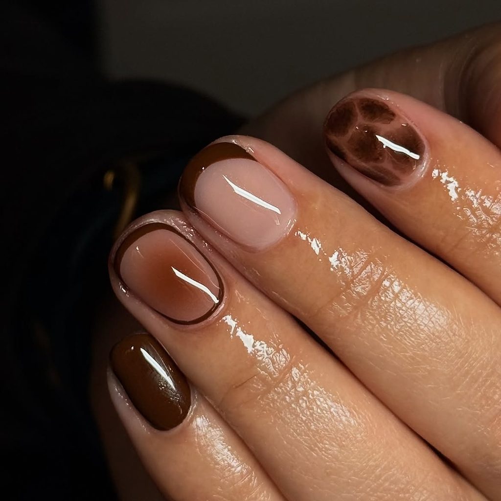 Short glossy nails with chocolate outline aura, curved French tip, and cracked tortoiseshell accent