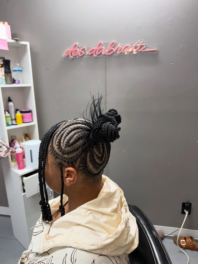 Braided hairstyle with two high buns, curved feed-in braids, and face-framing braids